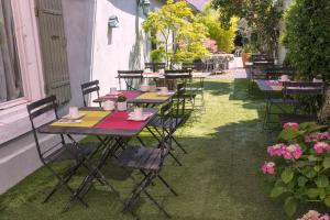 una fila de mesas y sillas sentadas en el césped en Hôtel du Parc, en Montélimar