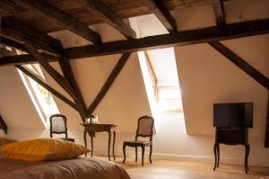 - une chambre avec un lit, deux chaises et une télévision dans l'établissement Unter der Linde, à Nordheim
