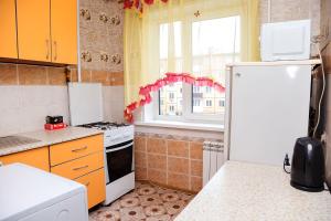 a kitchen with a white refrigerator and a window at Apartment on Krasnoarmeyskaya 137 in Kemerovo