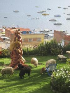 a group of sheep grazing next to a statue at Hotel La Cupula in Copacabana