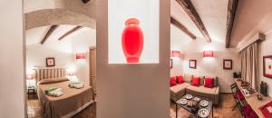 a room with two beds and a red vase on the wall at Borgo degli Ulivi in Porto Ercole