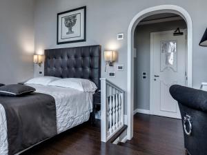 a bedroom with a large bed with a black headboard at Hotel Roma in Florence