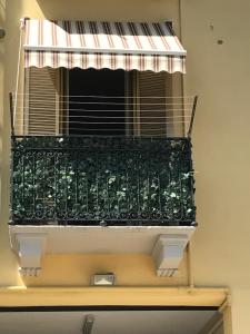 ミラノにあるSavona 91 Apartmentsのバルコニー(緑の手すり、縞模様の日よけ付)