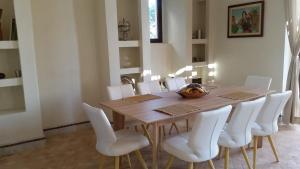 Marrakech Pearl في مراكش: غرفة طعام مع طاولة خشبية وكراسي بيضاء
