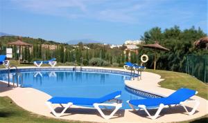 una piscina con tumbonas azules y una piscina en Casa Julia, en Casares
