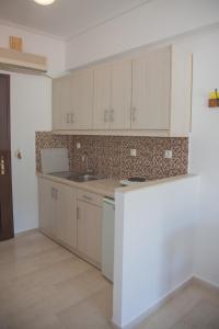 a kitchen with white cabinets and a counter top at Captain's Studios in Vasiliki