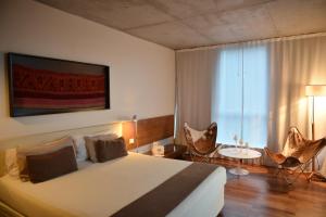 a bedroom with a large bed and a large window at Design Suites Salta in Salta