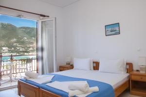 a bedroom with a bed and a balcony with a view at Captain's Studios in Vasiliki