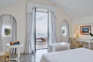 a bedroom with a bed and a view of the ocean at Caruso, A Belmond Hotel, Amalfi Coast in Ravello