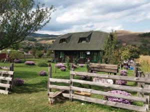 a wooden fence in front of a house with flowers at Holiday Home Vila Milka in Kremna