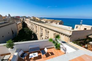d'un balcon avec des chaises et une vue sur l'océan. dans l'établissement ZIBIBBO SUITES & ROOMS - Aparthotel in Centro Storico a Trapani, à Trapani
