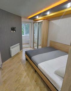a bedroom with a bed and a large window at Luxury 2 Rooms Apartments in Center by Green House in Poltava +12 photos