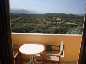 una mesa y sillas en una habitación con vistas en Calamon Apartments, en Episkopí- Rethimno