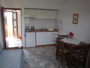 a kitchen with a table and a table and a dining room at Calamon Apartments in Episkopí- Rethimno
