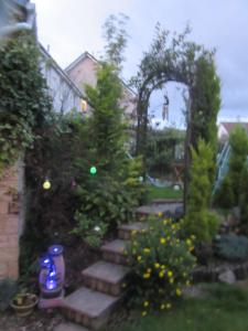 a garden with stairs and trees and an arch at Homely Haven, Dunfermline in Dunfermline