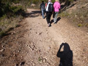 three people walking down a dirt path with their shadow at Chambres d'Hôtes Vue Mer L'Estérel Panoramique in St. Jean de l’Esterel