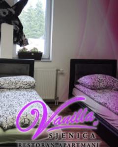 a bedroom with two beds and a sign that says pink at Guesthouse Vanilla in Sjenica