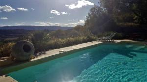 een zwembad met uitzicht op de bergen bij Les Rapieres Mireio in Gordes