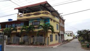 ein gelbes Gebäude mit Balkon auf einer Straße in der Unterkunft Hostal Dorys Mar in Puerto Baquerizo Moreno