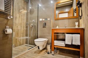 a bathroom with a toilet and a glass shower at Ameri Plaza Tbilisi in Tbilisi City