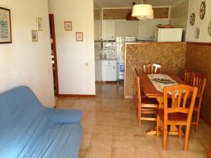 a kitchen and dining room with a table and chairs at Chalet turistico Riumar in Riumar