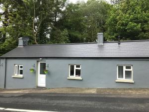 a blue house with two windows and a door at Hobbit Hollow in Ballymore Eustace