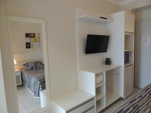 Habitación pequeña con cama y TV. en Pousada Ancoradouro's, en Florianópolis