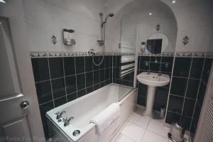 a bathroom with a bath tub and a sink at Prime 2 Bedroom City Centre Apt in Aberdeen