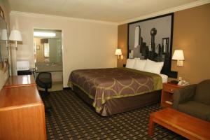 A bed or beds in a room at Super 8 by Wyndham Tyler TX