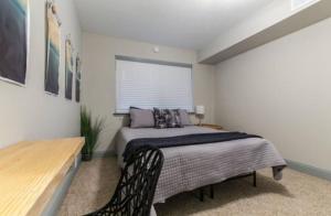 1 dormitorio con cama, mesa y ventana en Designed to Relax-NO PARTIES ALLOWED en Dallas