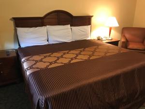 Rúm í herbergi á Alvin Extended Stay