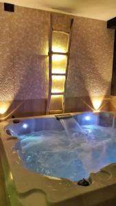 uma banheira azul com luzes na casa de banho em Piccolo Relais Galletto di Marzo Spa e relax solo per due em Paciano
