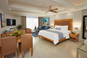 1 Schlafzimmer mit einem Bett und einem Esszimmer in der Unterkunft Divi Dutch Village Beach Resort in Palm-Eagle Beach