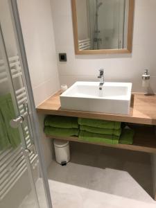 a bathroom with a white sink and green towels at Le Nautile in Hyères +18 photos