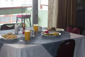 una mesa con platos de comida y bebidas. en Nuevo Maragato Hotel & Hostel en San José