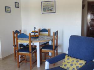 a dining room with a table and chairs at Apt com piscina em Alporchinhos in Lagoa