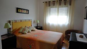 a bedroom with a bed and a window at Apt com piscina em Alporchinhos in Lagoa