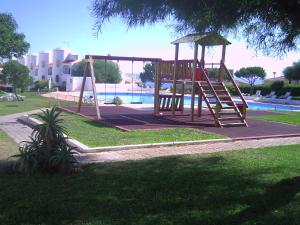 a playground in a park next to a pool at Apt com piscina em Alporchinhos in Lagoa