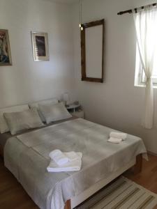 una camera da letto con un letto e due asciugamani di Joja Apartment Peljesac a Janjina