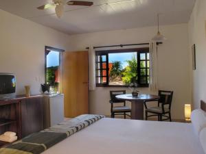 um quarto com uma cama, uma mesa e uma televisão em Resort Monte das Oliveiras em Joanópolis mais 89 fotografias