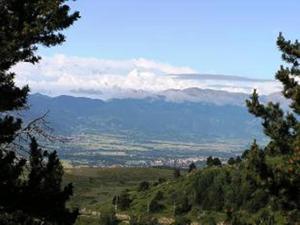 Elle offre une vue sur une vallée avec des montagnes et des arbres. dans l'établissement Résidence Le Parc, à Font-Romeu-Odeillo-Via
