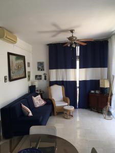 un soggiorno con divano blu e ventilatore a soffitto di Joja Apartment Peljesac a Janjina