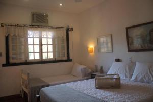 a bedroom with two beds and a window at Aquarius Osteria in Arraial do Cabo