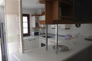 a kitchen with white cabinets and a white counter top at Adosado junto a Mar in Estepona