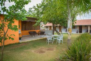 a patio with chairs and a table in a yard at Pousada Vento Sul in Chapada dos Guimarães +65 photos