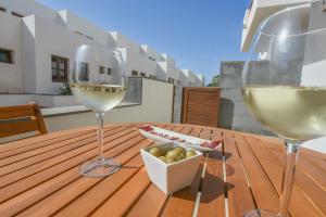 two glasses of wine and a bowl of olives on a wooden table at Casa Zen in Puerto Calero