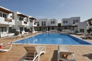a large swimming pool with chairs and a hotel at Casa Zen in Puerto Calero