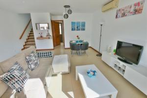 a living room with a couch and a tv at Casa Zen in Puerto Calero