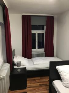 a bedroom with a bed and a window with red curtains at Ferienwohnung "Zur Ottoburg" in Schlitz in Schlitz