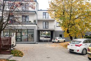 budynek z dwoma samochodami zaparkowanymi przed nim w obiekcie Apartament 48m w centrum Grójca w mieście Grójec